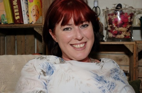 Redhead amateur BBW smokes while sliding cutoff shorts aside on a couch