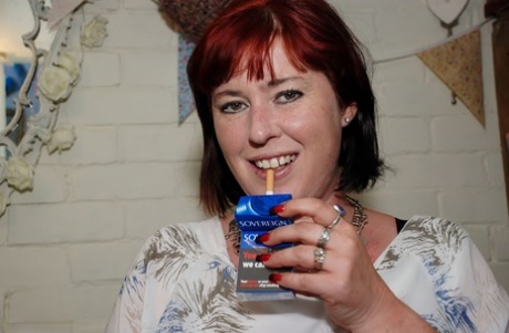 Redhead amateur BBW smokes while sliding cutoff shorts aside on a couch