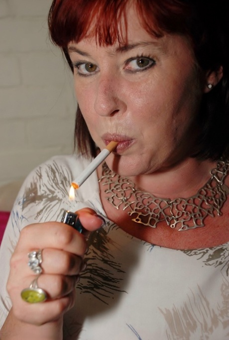 Redhead amateur BBW smokes while sliding cutoff shorts aside on a couch