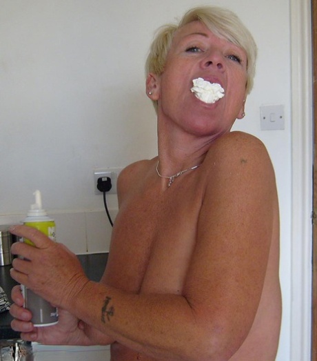 Older woman with short blonde hair Shazzy B covers her tits & twat in cream