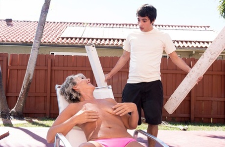 Topless mature woman Constance Joy seduces the young deck boy