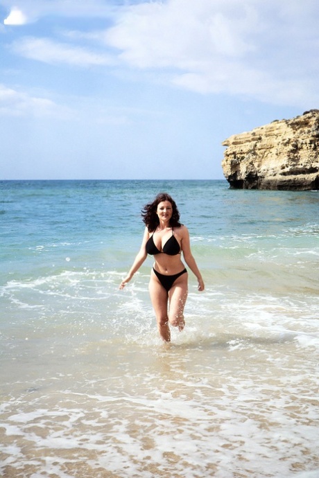Brunette MILF Lorna Morgan releases her nice melons from bikini on a beach