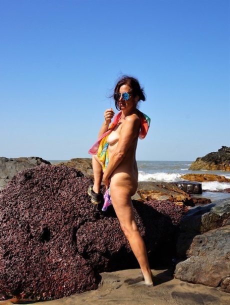 Mature amateur Diana Ananta is joined on the beach by her nudist friends