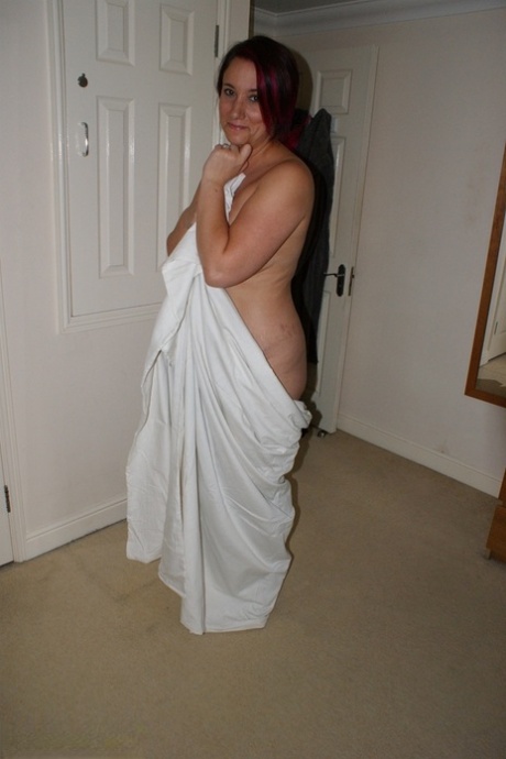 Overweight redhead models completely naked while in her bedroom
