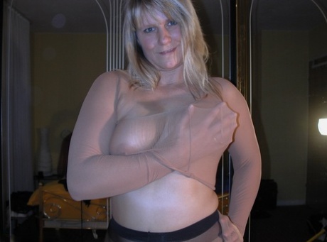Middle-aged amateur Sweet Susi pulls on sheer pantyhose before going topless