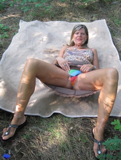 Mature lady has POV sex on a spread out blanket in the outdoors