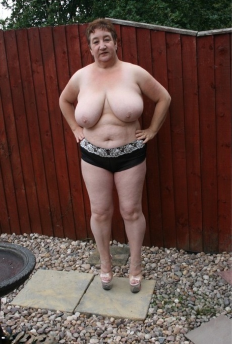 Overweight British woman Kinky Carol gets naked in high heels in a backyard