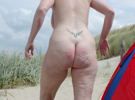 Mature lady Tiffany Pearl wears nothing but sunglasses while at the beach