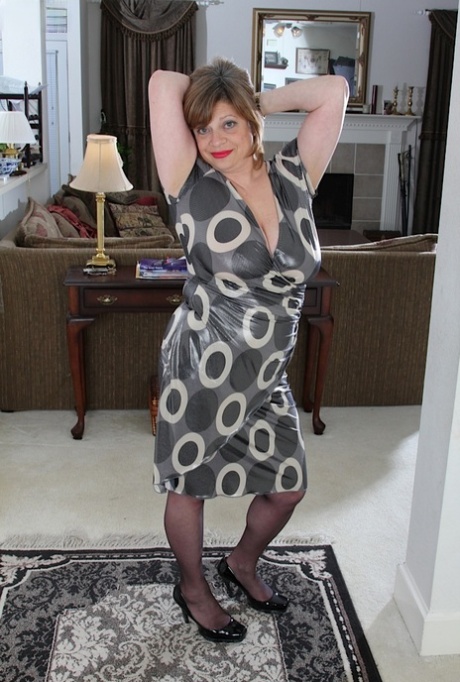 Mature woman Kathy Gilbert holds her large tits as she disrobes for nude poses