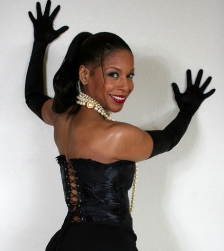 Ebony mature Semmie Desuora revealing her melons from a classy corset dress