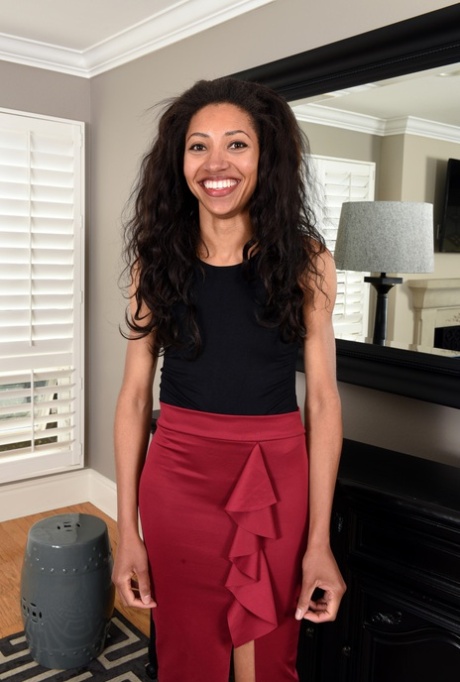 Mature ebony Cree Morena takes off her red dress and poses naked in her room