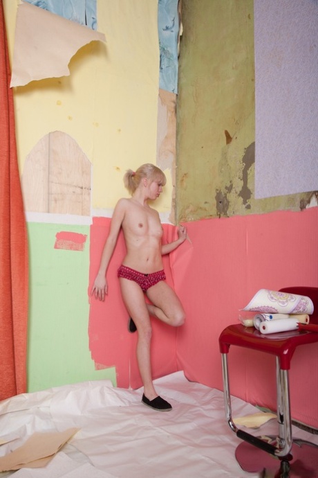 Amateur blonde Nomi displays her hairy pussy and naturals on the floor