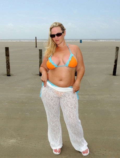 Short MILF Dee Siren strips on the beach & exposes her monster curves