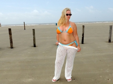 Short MILF Dee Siren strips on the beach & exposes her monster curves