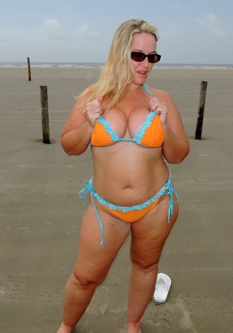 Short MILF Dee Siren strips on the beach & exposes her monster curves
