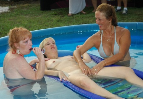 Playful mature sluts rubbing each other's love holes in the pool