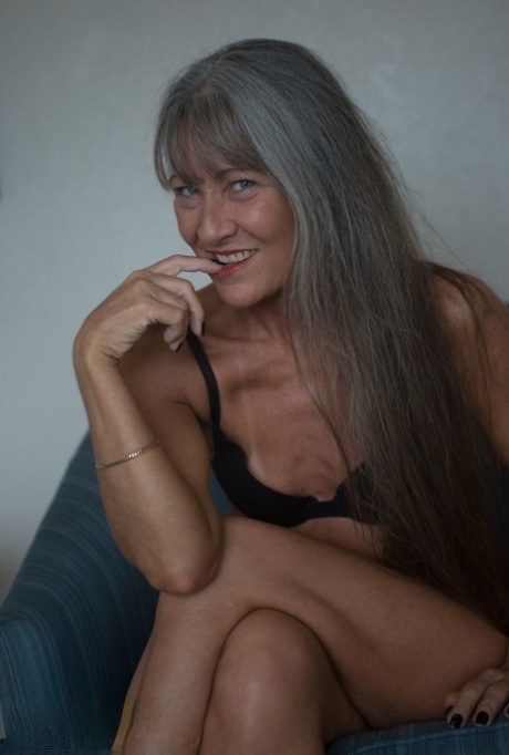 Sweet mature MILF with tiny tits Leilani Lei strips and poses on a bed