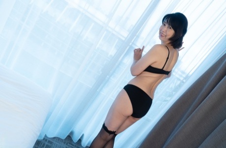 Mature Japanese lady Yoshiko Kitano shows off her petite body in stockings