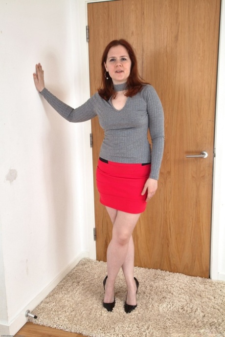 Luscious lady Kathy sitting on the carpet spreading her furry vagina
